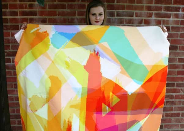 Lottie Milbank, a Northbrook MET textile design degree student, with a large-scale version of her design