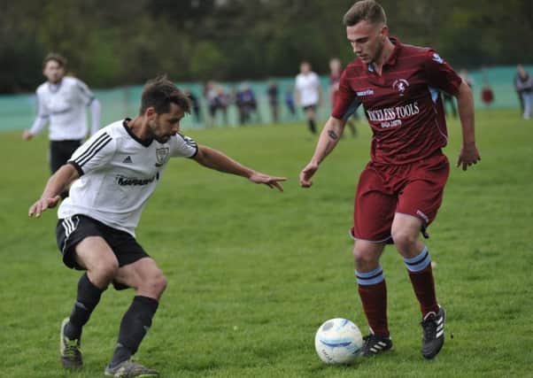Little Common midfielder Harry Saville tries on to take on Bexhill United's Brett Patton. Pictures by Simon Newstead