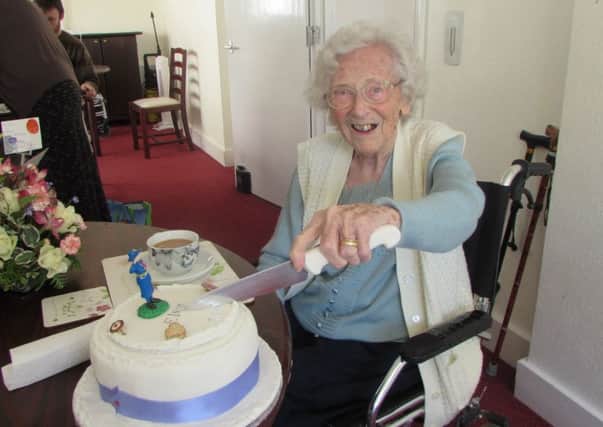 Elsie Pickles cutting her birthday cake in celebration of turning 104