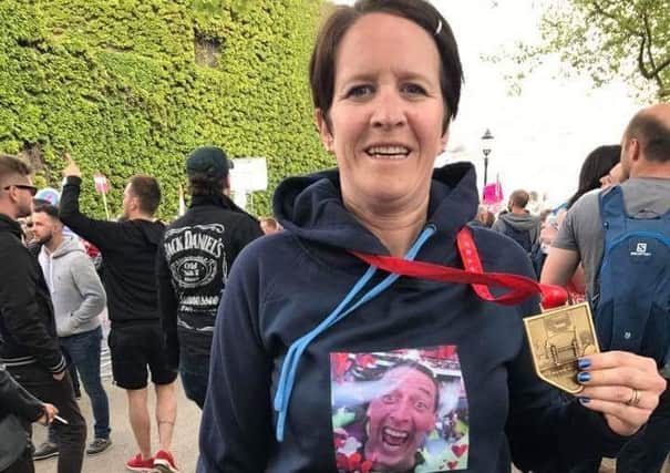 Claire Overfield proudly shows off her London Marathon medal SUS-170426-120640001