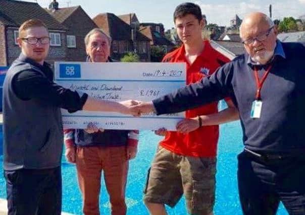 Arundel Co-op team manager Karn Moore presents a cheque to David Wood, chairman of the trustees, and staff at Arundel Lido