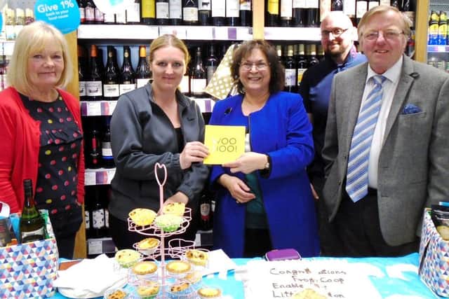 Field Place Co-op manager June Caffyn with Littlehampton Shopmobility chairman Alan Gammon as Cheryl Dennis presents a card  signed by staff