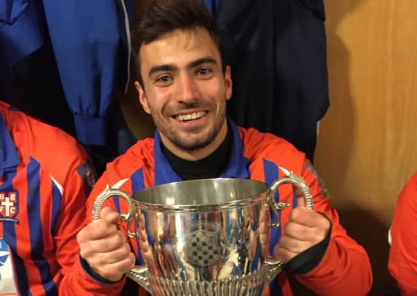 Yordan Yordanov clutches the Premier Travel Challenge Cup after scoring for Battle Baptists in their victory over Hollington United. Picture courtesy Andrew Hazelden