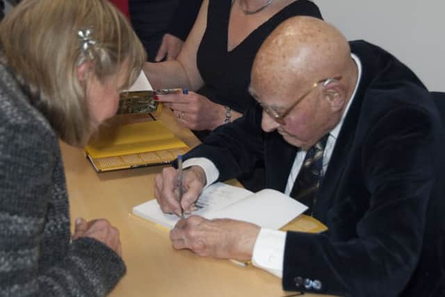 William signing copies of his book