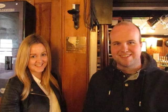 Hannah and Nathan next to the plaque in the Chequer Inn pub