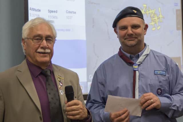 Sqn Ldr Dick Kharegat presents a cheque to group Scout leader Daniel Jones