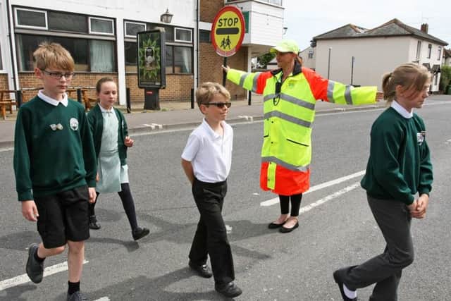 Lollipop lady Carol Jannaway helping White Meadows Primary Academy pupils cross Wick Street. Left to right: Fletcher Newell, 10, Poppy Foster, seven, Frank Smith, nine and Aimee Green, nine.