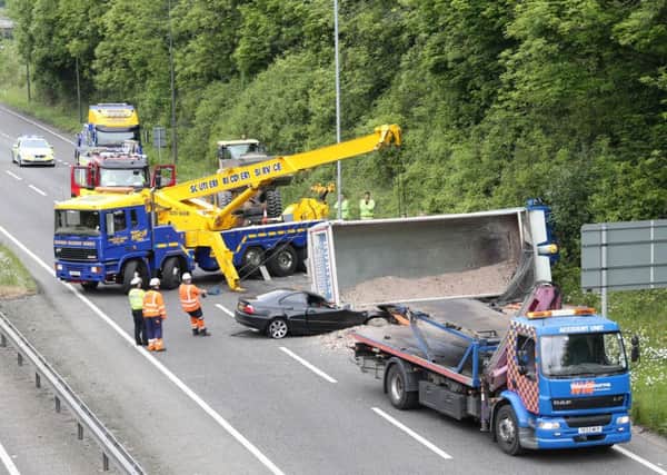 Clearing up the carriageway on the A23 after a lorry toppled onto a car and shed its load. Photo: Eddie Mitchell SUS-170518-123605001
