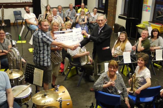 David Healy and Mallory Hansford presenting Ian Morgan with a cheque for the total raised. Photograph: contributed