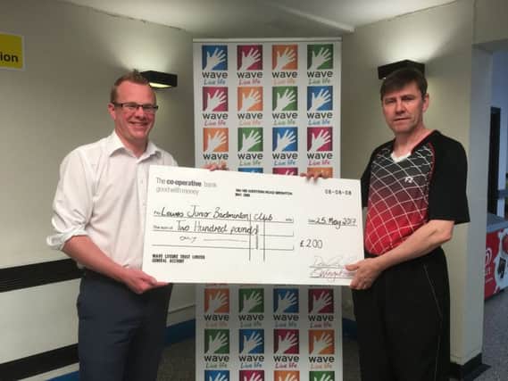 Dan Chambers (left) presents a cheque for Â£200 to a representative from Lewes Junior Badminton Club