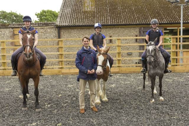 Harry Meade with three horse riding students at Lancing College
