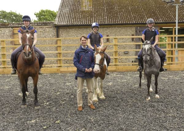 Harry Meade with three horse riding students at Lancing College