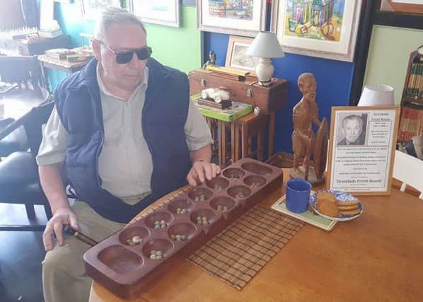 George Doughty at Grandad's Front Room with the Oware board game. Pic: Danny Dawes