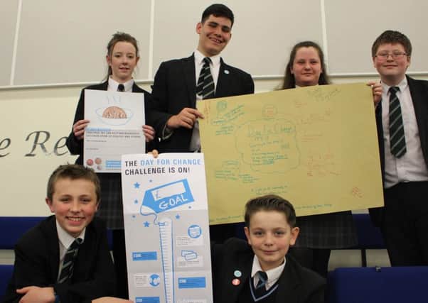 Students show their planning for Day For Change at The Regis School
