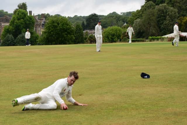 Bexhill's overseas player Jake Lewis slides to gather the ball. Picture courtesy Andy Hodder