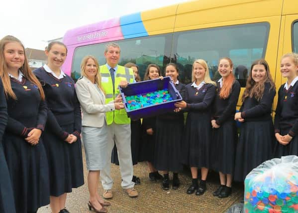 Davison pupils helps Clare Sutton deliver the milk bottle tops to Steve Deane