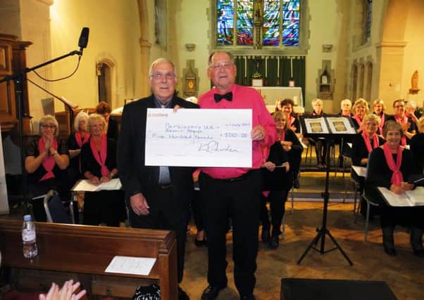 Treble Clefs musical director Keith Richardson presents a cheque for Â£500 to James Vidler, Chairman of the Bexhill branch of Parkinsons UK