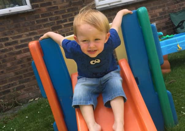 Alfie, aged two, enjoying his slide in the communal gardens