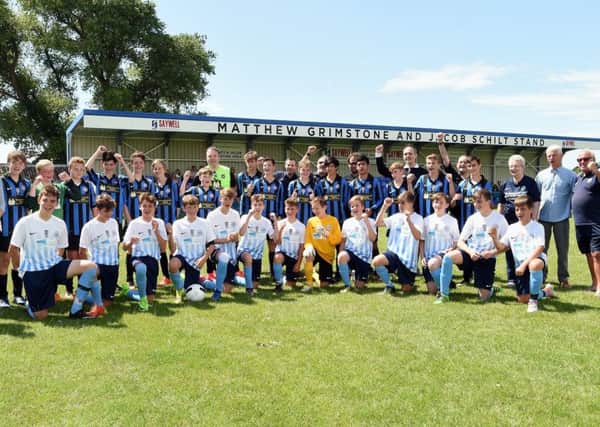 Worthing United U15 and Worthing Town U15 with sponsors and dignitries with the Matthew Grimstone and Jacob Schilt memorial stand behind. Picture: Liz Pearce