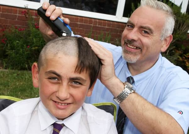 DM17737097a.jpg Oscar Thompson,10, has his head shaved in aid of St. Barnabas Hospice. Dad Andrew cuts it off at his school, St Catherine's Catholic Primary, Wick. Photo by Derek Martin. SUS-170725-180421008