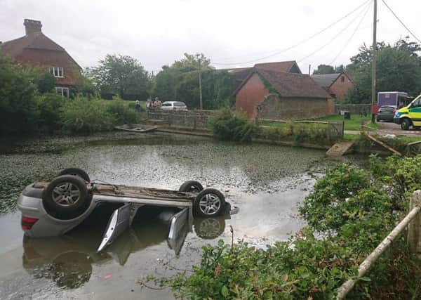 Car flips into lake in Loxwood.