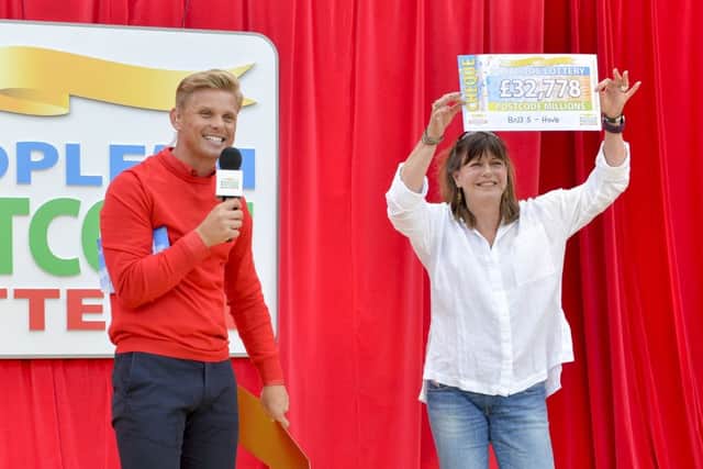 Pictured at the seafront in Hove are the Peoples Postcode Lottery winners from postcode BN3 5 receiving their winner's cheques. Shown is Ambassador Jeff Brazier presenting the cheque to Amanda Norgate. Pictures Copyright Darren Casey / DCimaging 07989 984643 Peoples Postcode Lottery