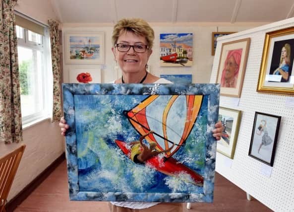 Pauline Parkinson with her painting Riding the Wave, which was inspired by windsurfers near Sea Lane Cafe in Goring.  
Picture: Liz Pearce LP170568