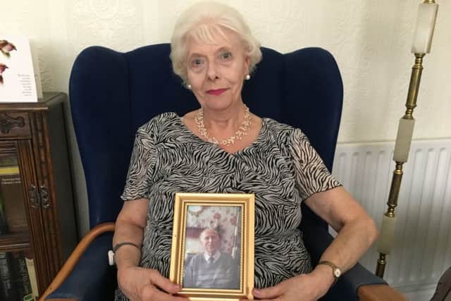 Mildred Potter, 79, with a photo of her husband