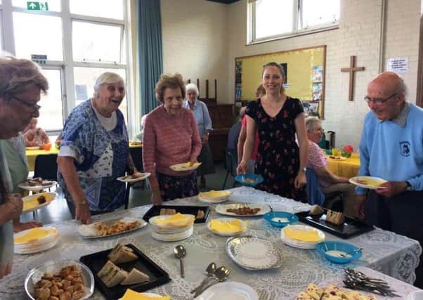 Katie Orchin, second right, serves afternoon tea at The Friday Club at The Church of the Good Shepherd