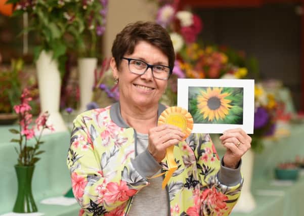 Show secretary Sally Evans with her winning sunflower photo, which will feature on the front of next year's show schedule. Pictures: Liz Pearce LP170645