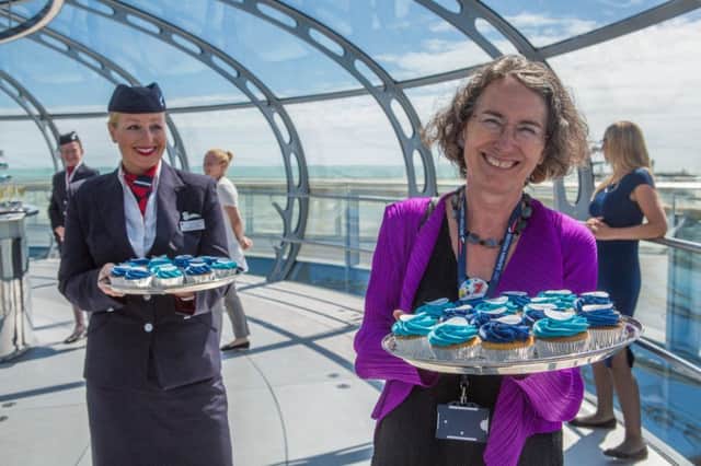 Julia Barfield hands out birthday cupcakes at the i360's one year anniversary celebration