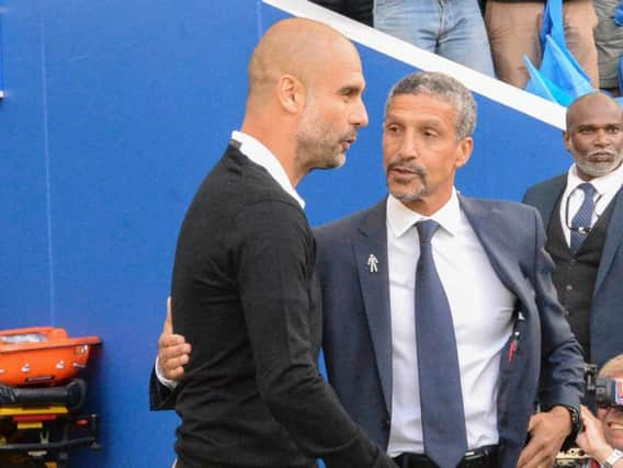 Brighton & Hove Albion manager Chris Hughton greets Pep Guardiola on the sides on Saturday. Picture by PW Sporting Pics