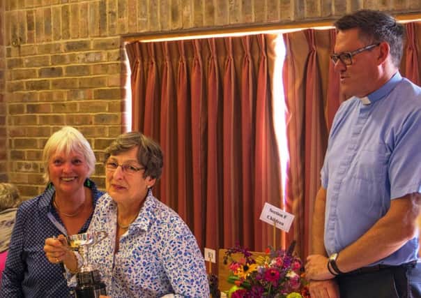 Sue Buckingham and Mary Daubeny with vicar Derek Welsman, who presented them with the Brecknock Cup for floral arrangements