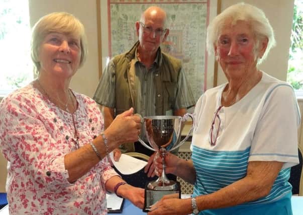 Jackie Haggis presents Jenny Duncan with the Jock Ledingham Cup for best in show for her stunning begonia plant, watched by chairman John Humphris