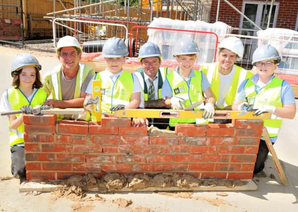 From left, Max Scott 11, bricklaying foreman Gerry Finnegan, Owen Thorpe, ten, site manager Jamie Tanner, Luca Zanetti-Buckland 11, bricklayer Steve Burns and Nathan Blake, 11