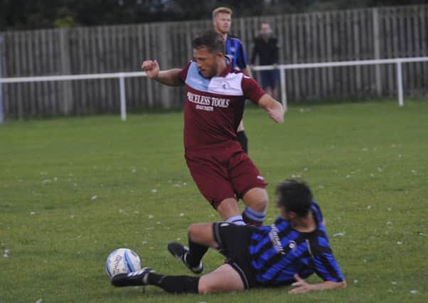 Langney Wanderers defender Dom Clarke slides in on Little Common forward Jamie Crone. Pictures by Simon Newstead