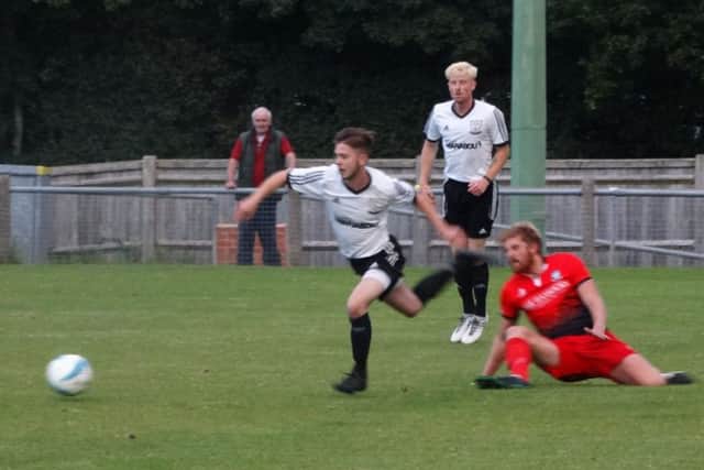 Bexhill United midfielder Kyle Holden evades a sliding Hassocks opponent. Picture courtesy Mark Killy