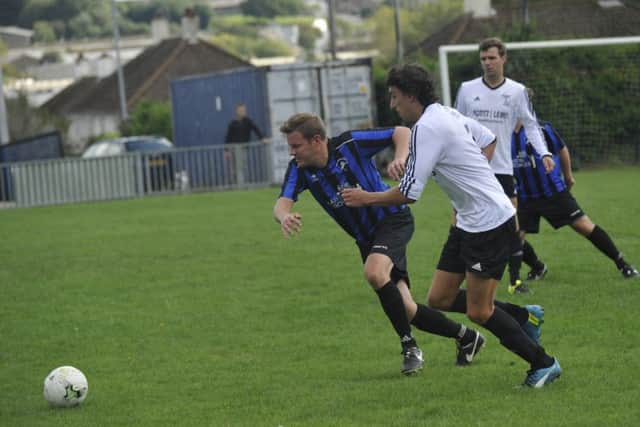 Hollington United II and Bexhill United II tussle for possession.