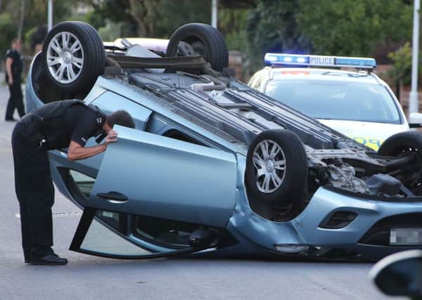 Police at the scene after car rolls on roof in Trent Road. Photo by Eddie Mitchell
