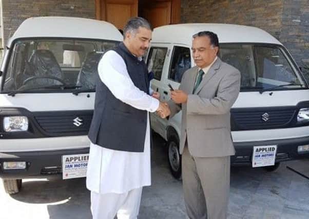 Dr Shakil Malik presents the keys of the vans to a trustee of  the Centre for Profound Education, Islamabad