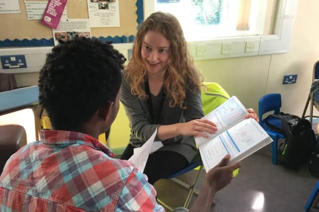 Tazmin helping a young refugee with reading