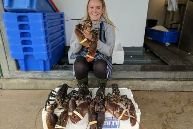 Alexandra Brooks, 19, who works at Riverside Fish, with the five nine-pound lobsters. Picture: Simon Finch