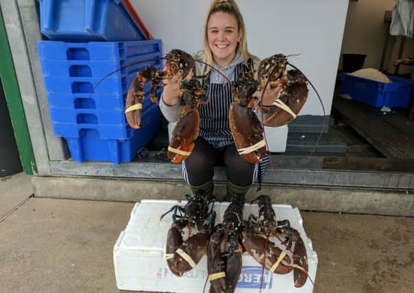 Alexandra Brooks, 19, who works at Riverside Fish, with the five nine-pound lobsters. Picture: Simon Finch