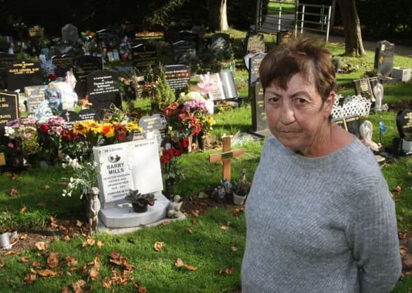 Carol Mills is hoping to raise money for a bench in Littlehampton cemetery. Mrs Mills is pictured beside the grave of her husband. Photo by Derek Martin Photography
