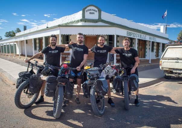 Chris Rollings, left, with friends Keith, Benny and Tim at the finish line, the Birdsville Hotel in Queensland. Picture: Benny Littlejohn