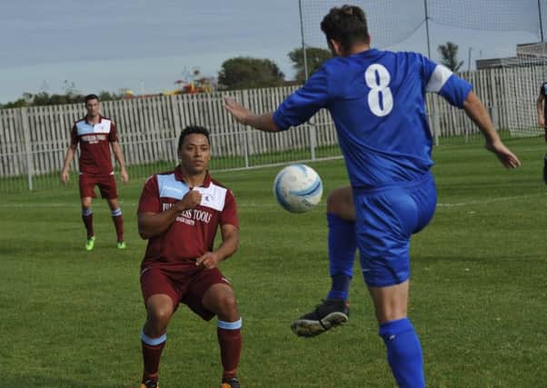 Wes Tate stands in the way of Storrington midfielder John Rhodie last weekend. Picture by Simon Newstead