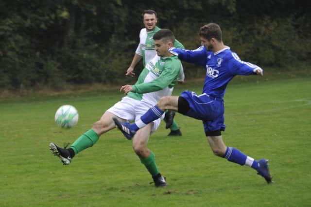 The Icklesham Casuals full-back clears under pressure from a St Leonards Social II opponent.