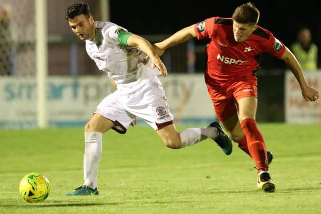 Jack Dixon holds off a Carshalton Athletic opponent on Tuesday night. Picture courtesy Scott White