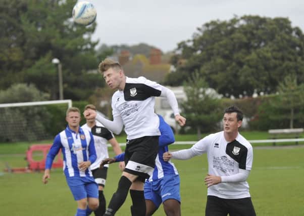 Bexhill United wide player Corey Wheeler wins a header against Lingfield this afternoon. Pictures by Simon Newstead
