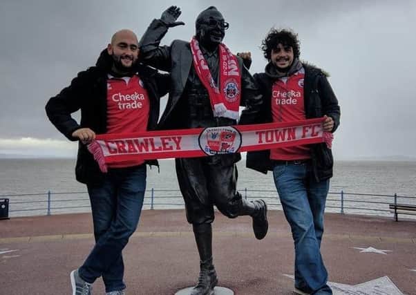 Crawley Town fans with the statue of Eric Morecambe at Morecambe. Pic by Steve Herbert SUS-171010-094951002